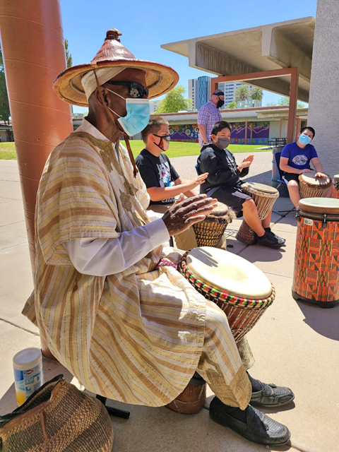 Emerson music students drum with teaching artist Keith Johnson.